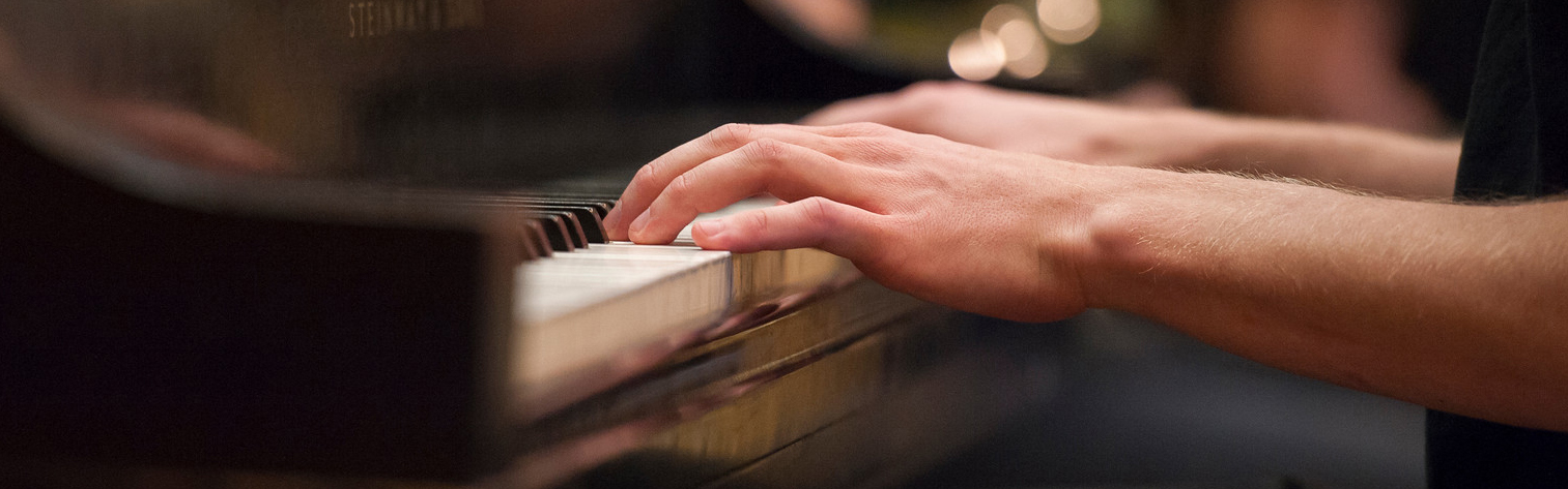 Student playing the piano during a musical performance on campus.