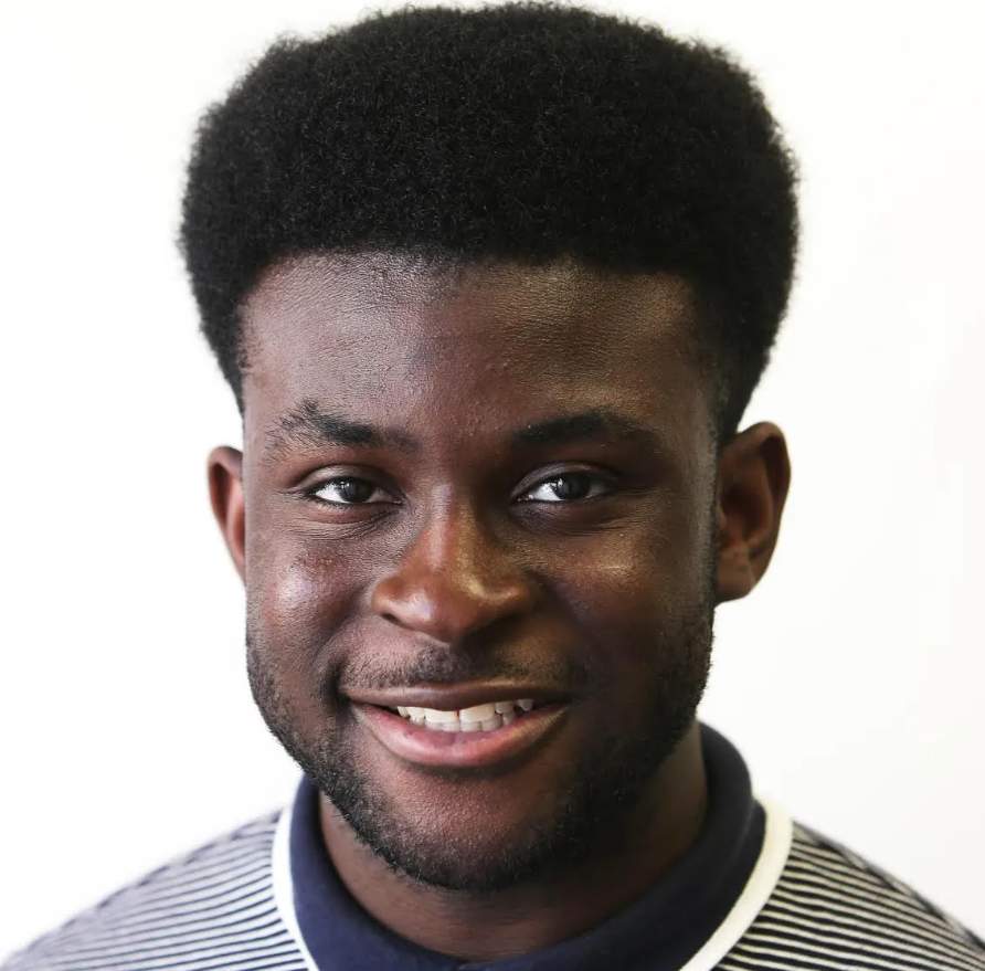 Photo of Ben Arthur, a black man smiling with a blue and white shirt