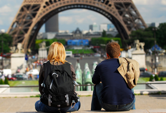 View of tourists sitting in the park surrounding the Eiffel Tower in Paris, France.