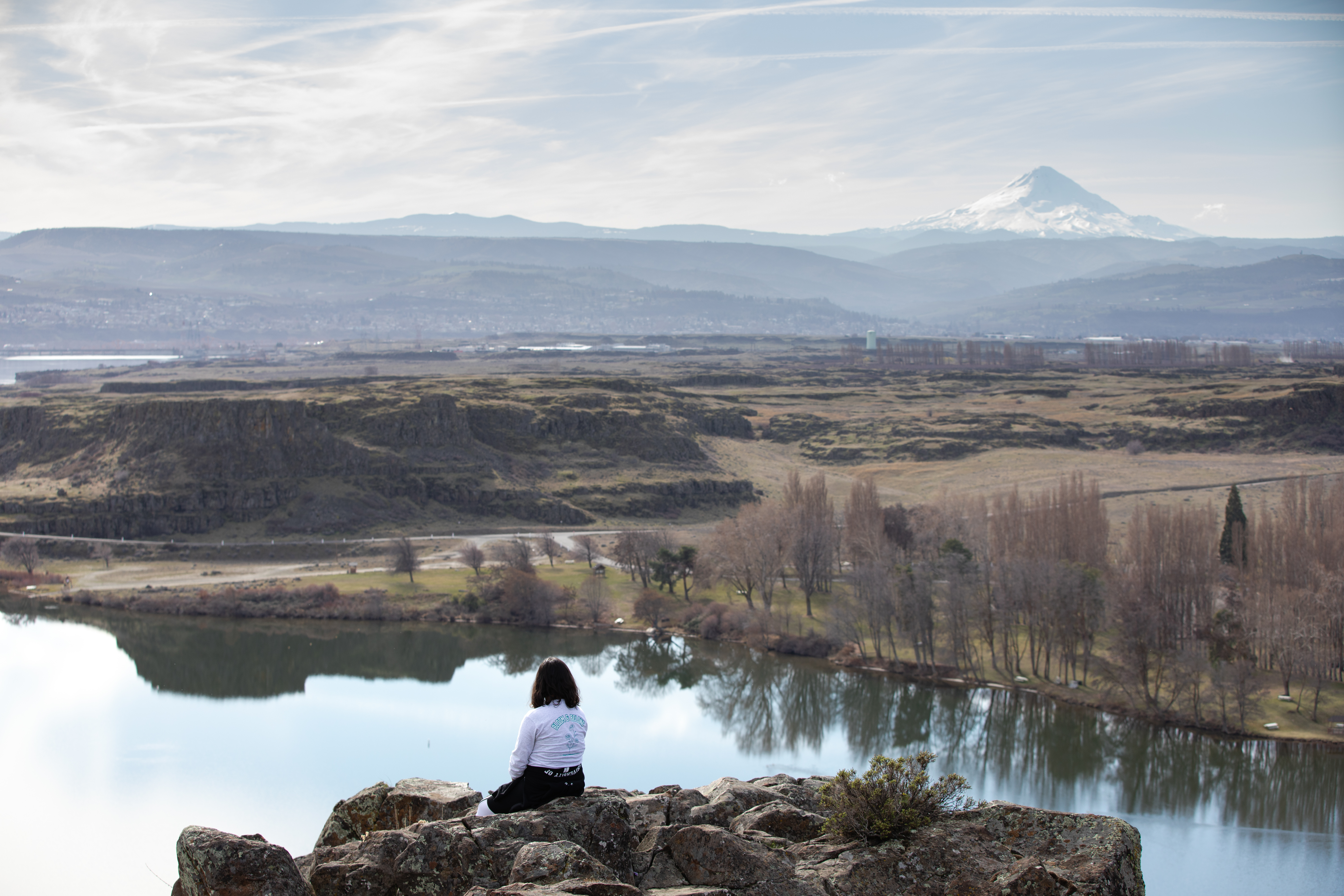 A student looking over the Columbia River Gorge, with Mt. Hood in the background.