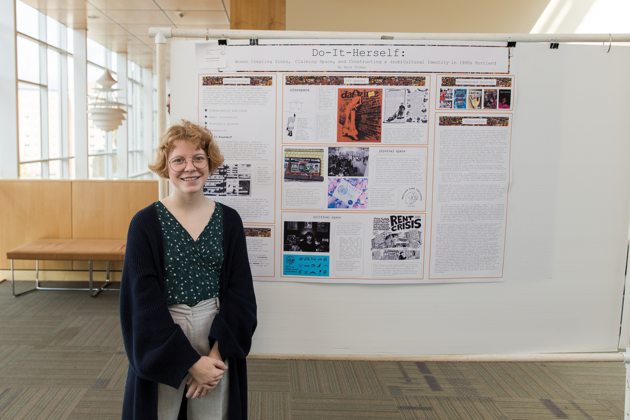 A student standing in front of her Founders' Day poster