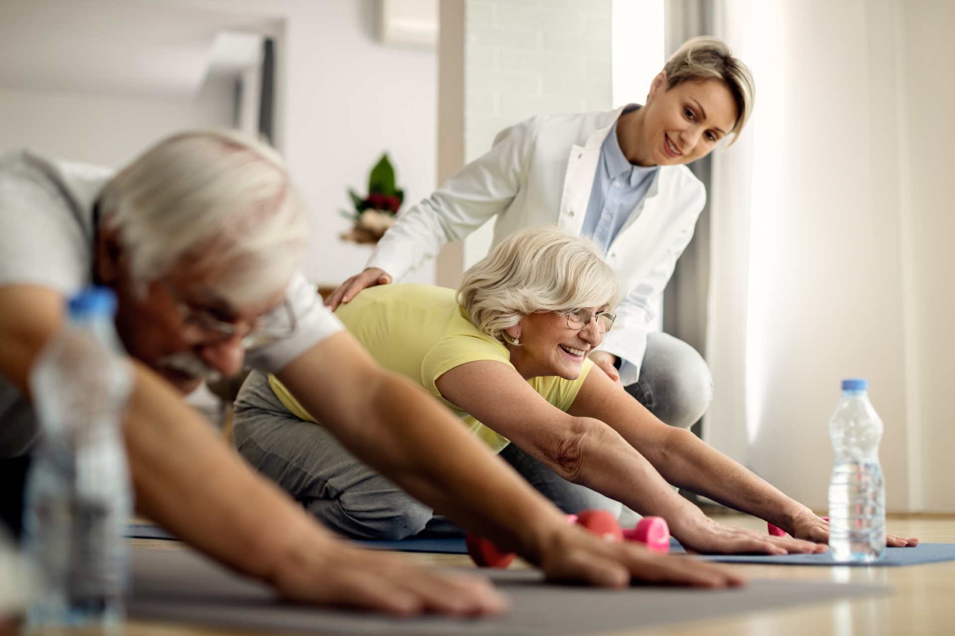 An instructor helps a group of seniors with a fitness class