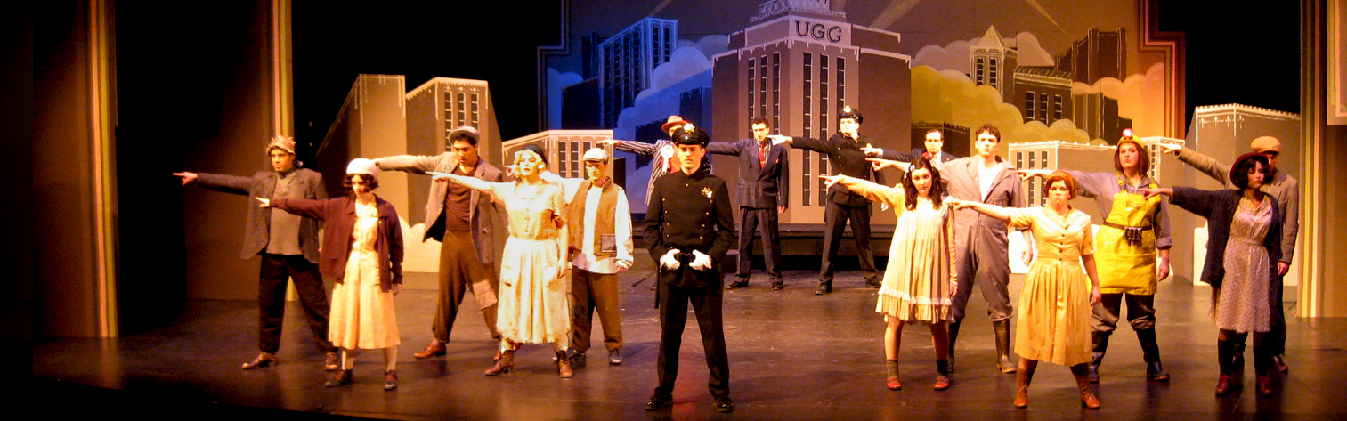 Actors onstage in a production of Urinetown The Musical