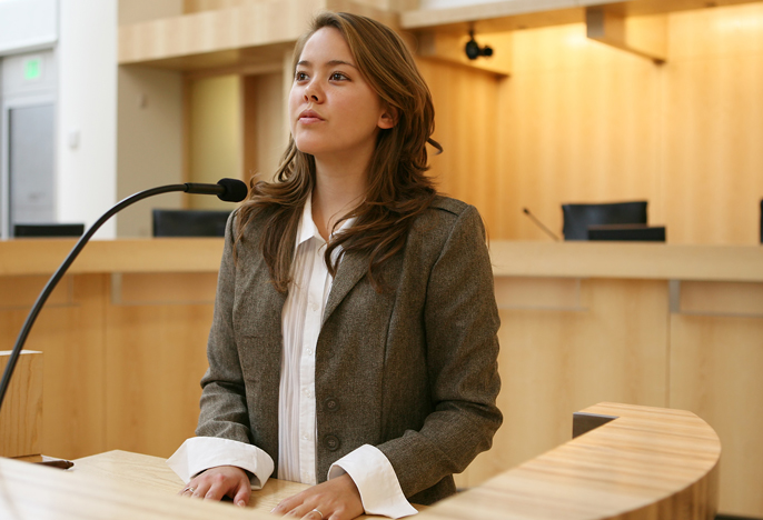 Photo of a female student in mock trial in courtroom.